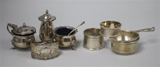 A 1970s silver three piece condiment set, a silver tea strainer and stand, and three silver serviette rings.